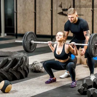 Woman Lifting Up A Burbell With Coach In The Gym 2026 01 08 22 30 52 Utc