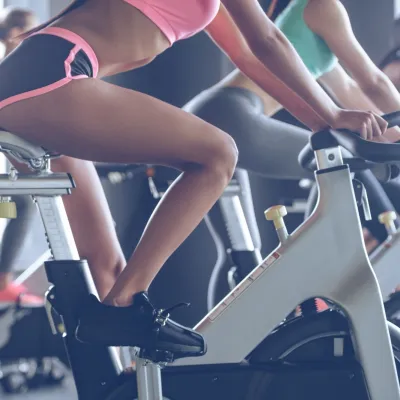 Women Exercising On Stationary Bikes In Gym 2026 01 08 02 39 47 Utc